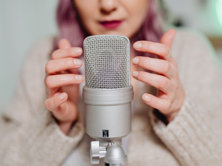 A narrator recording an audiobook with a studio microphone