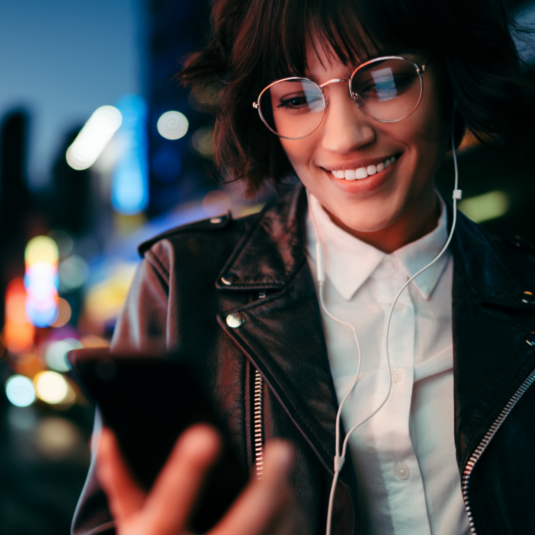 woman listening to audiobooks and reading her phone with a cityscape in the background